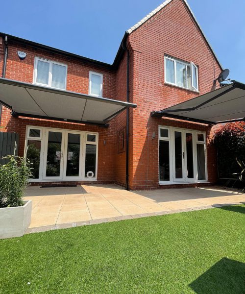 Modern house with 2 retractable awnings over patio