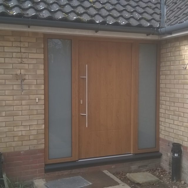 Golden oak front door with side glazing and large handle