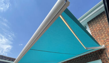 Blue awning above glass table.