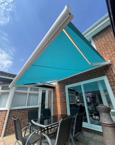 Blue awning above glass table.