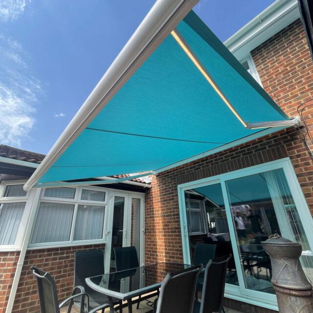 Blue awning above glass table.