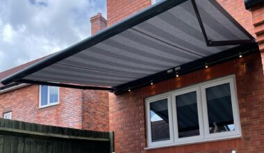 Grey awning above picnic table.