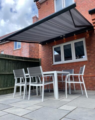 Grey awning above picnic table.