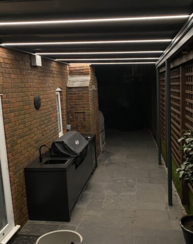 Lights attached to a veranda covering a BBQ.