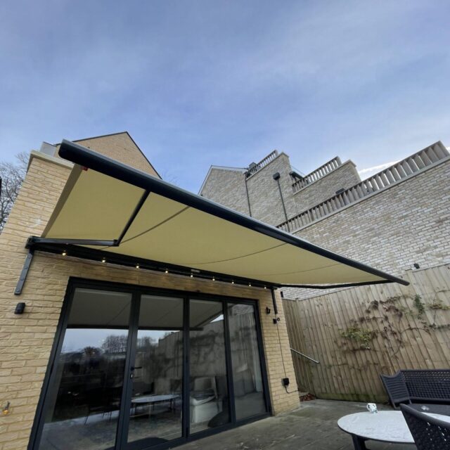 Yellow awning covering grey paving stone.