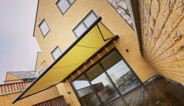 Yellow awning covering wooden decking.