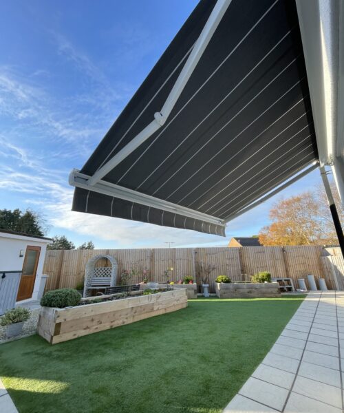 Grey striped awning covering a white patio.