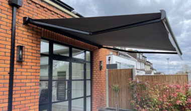 Dark grey awning covering a large glass door.