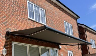 Red brick house with an electric awning.