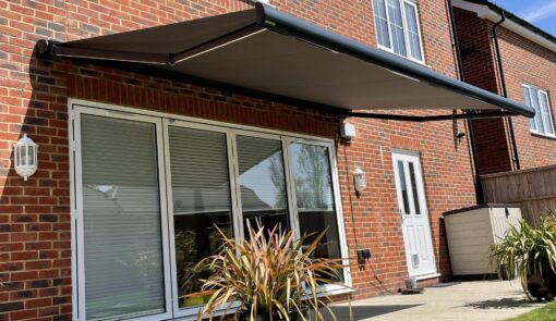 Red brick house with an electric awning. - Cyra Group Ltd